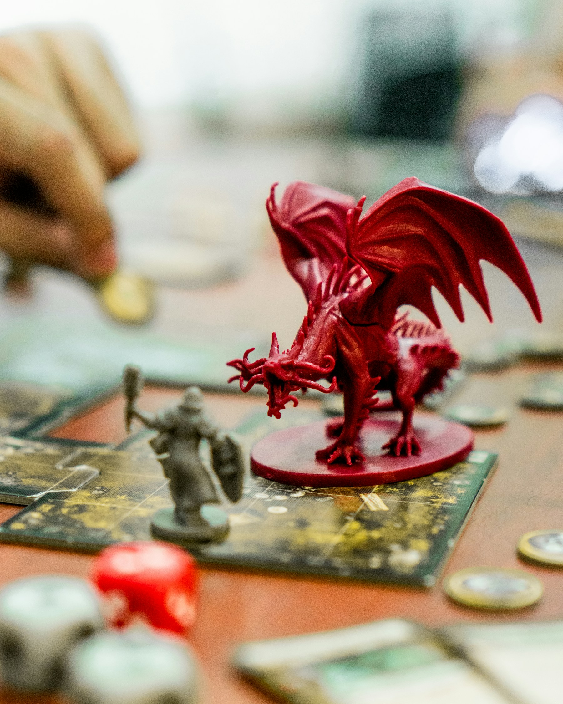 Red dragon miniature facing an armoured knight on a tabletop game board